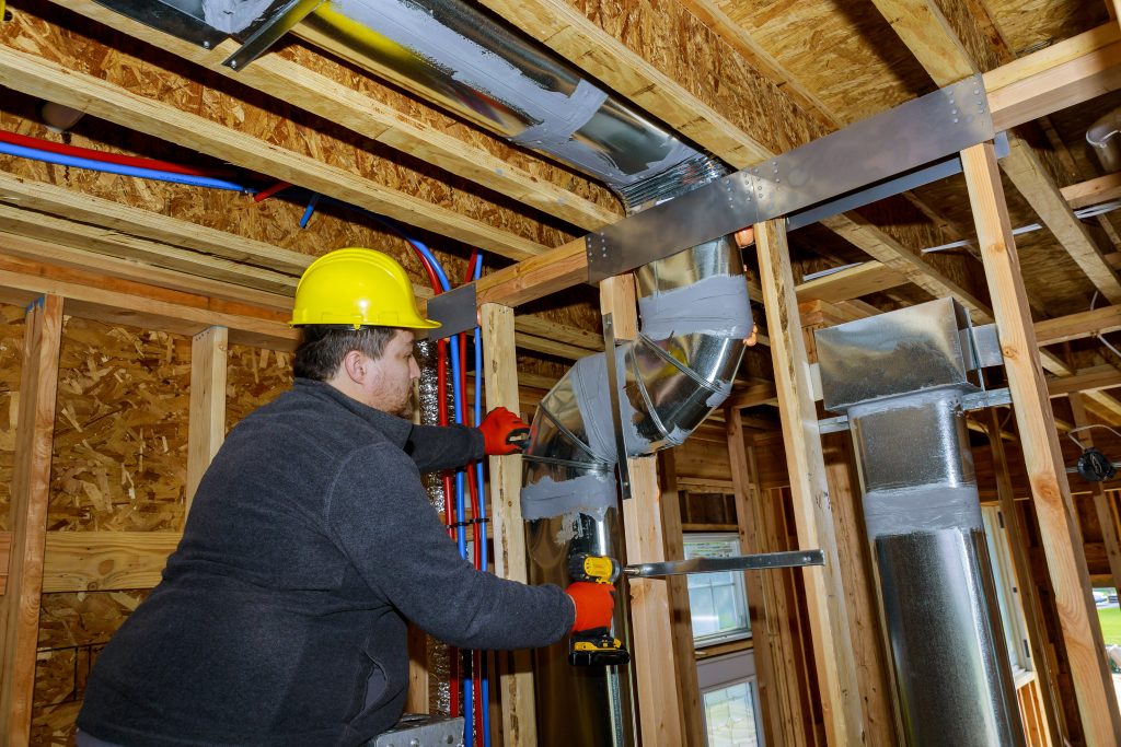 Technicians adjusting the pipes during installation, highlighting the versatility of HVAC customized solutions.