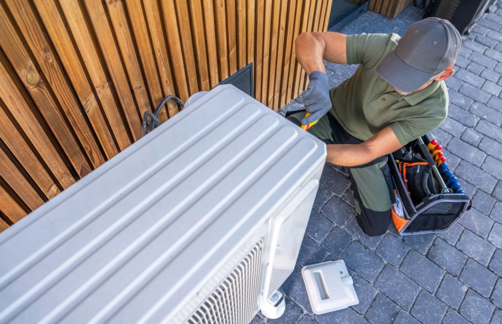 Experienced HVAC technician servicing an outdoor AC unit.